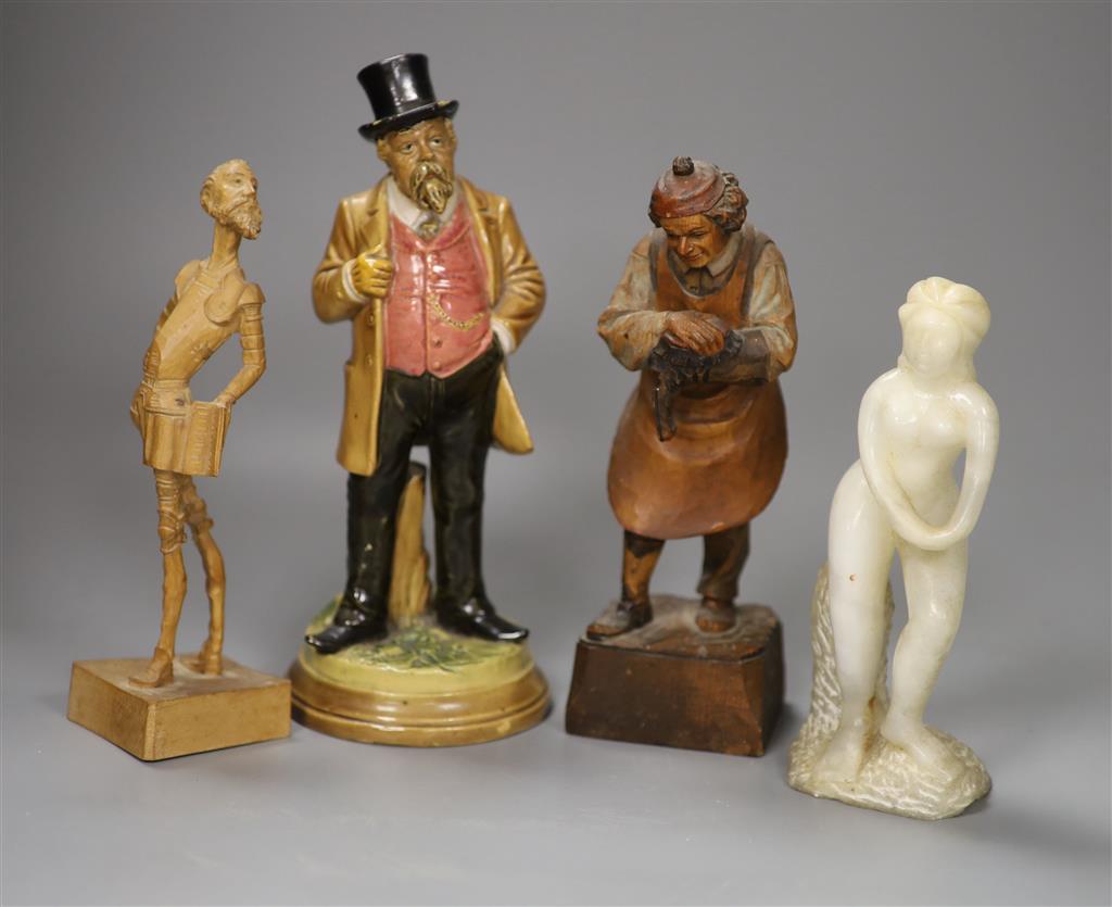 A German pottery figure and two alpine carved wood figures and a soapstone figure, tallest 21cm